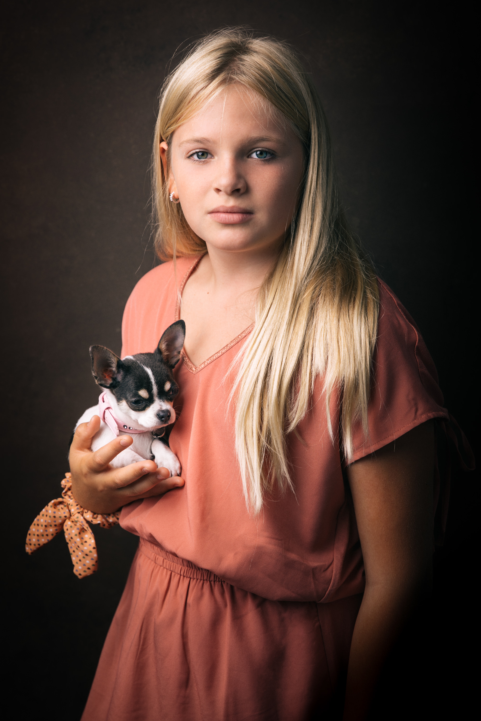 Jeune fille tenant son chien dans les bras, regard plein d’amour