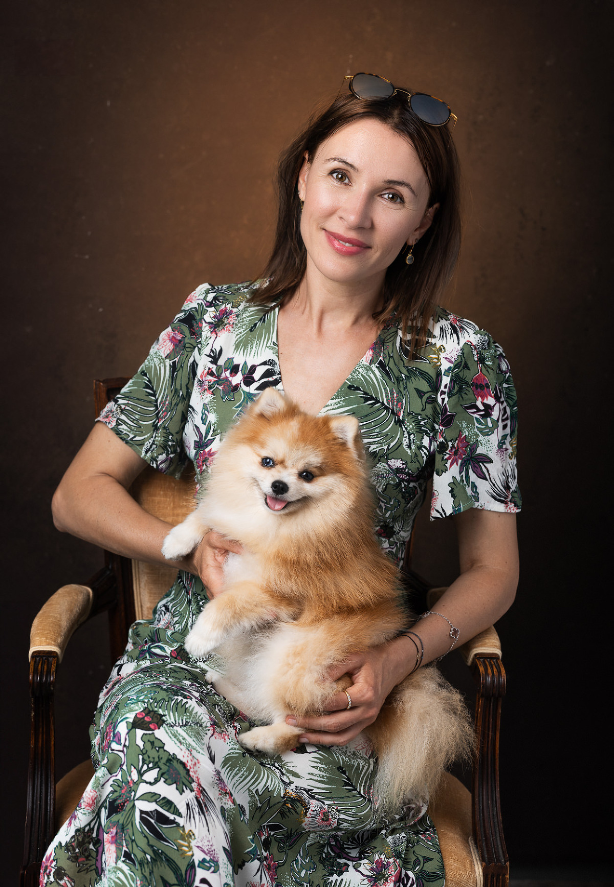 Maîtresse et chien posant ensemble en studio, lien unique immortalisé.