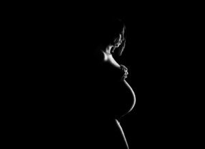 Portrait artistique d’une future maman tenant son ventre arrondi